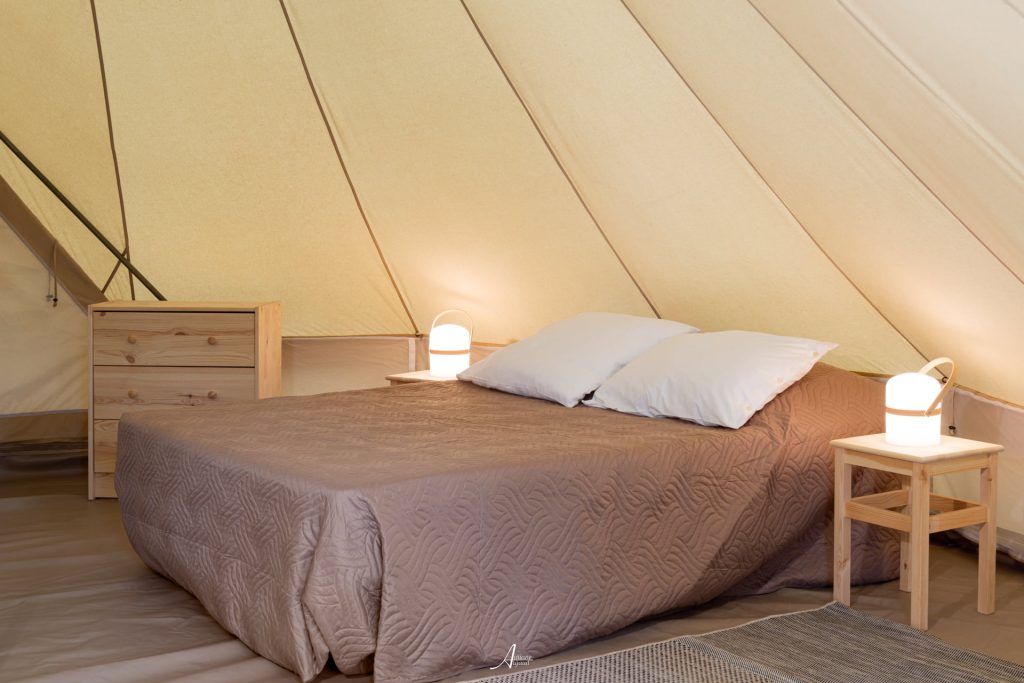 Schlafzimmer mit Doppelbett in einem Safarizelt auf dem Camping U Casone